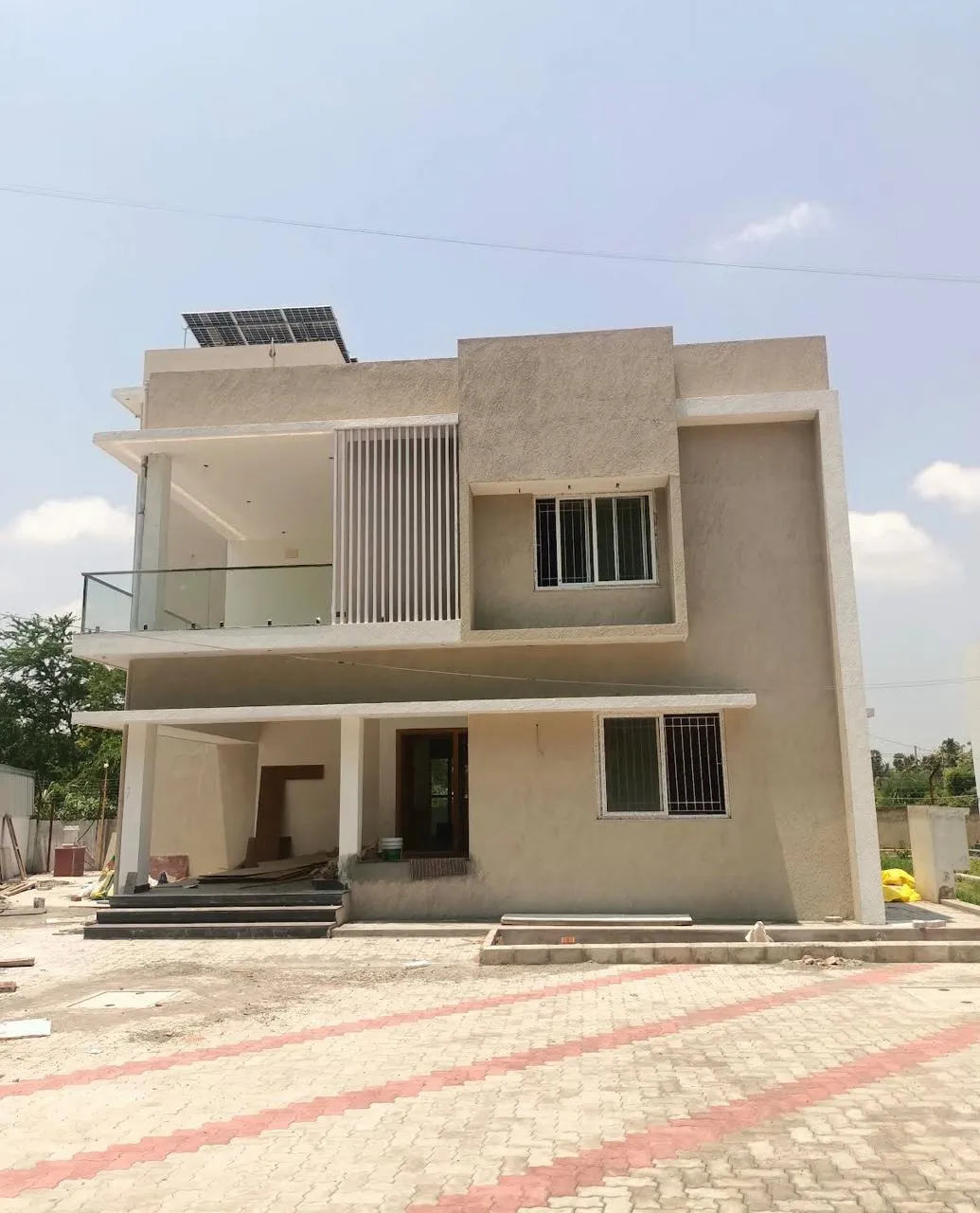 Two-storey residence finished in textured cream with balcony and fluted screen